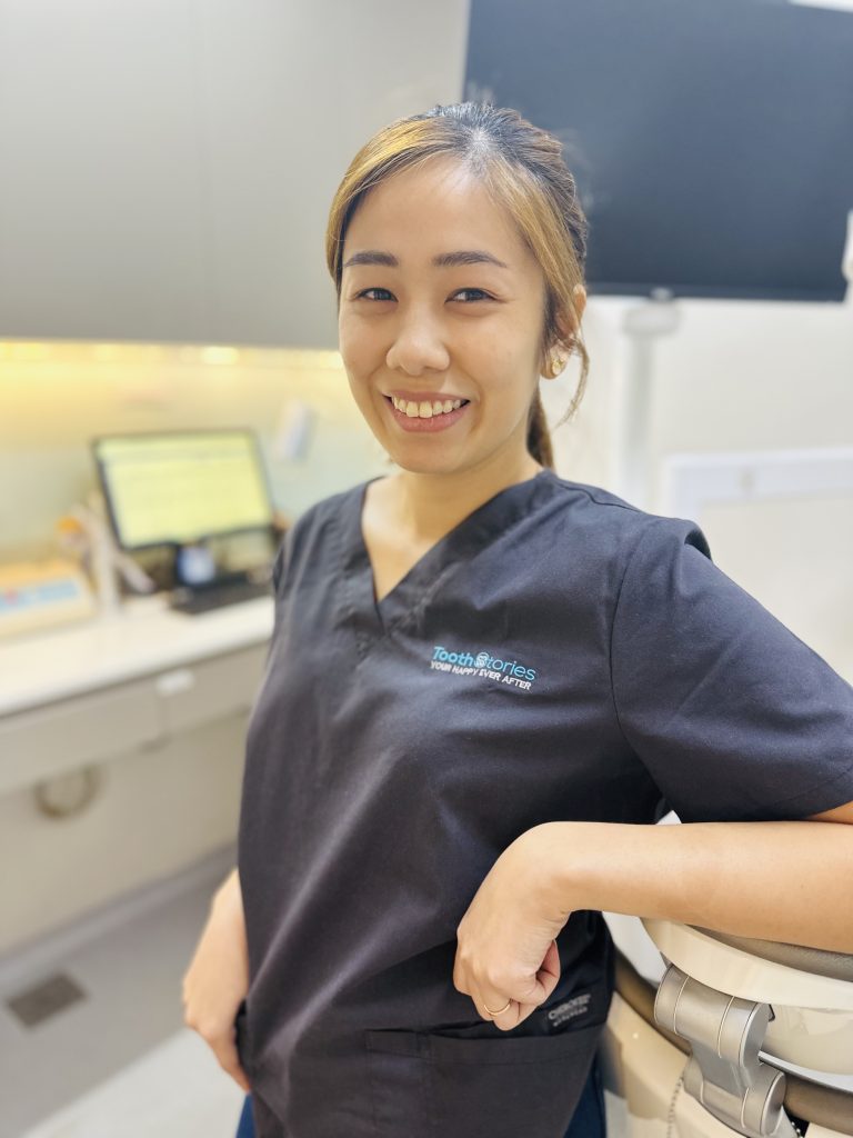 dentist smiling in uniform at tooth stories dental clinic